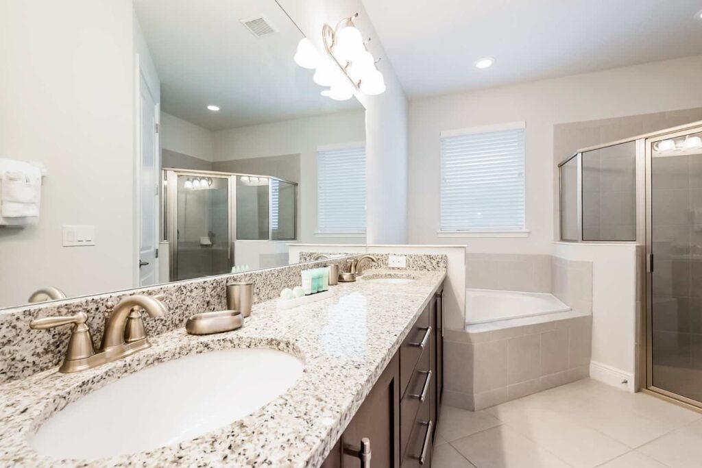 Bathroom with double sinks, walk-in shower, and separate bathtub in an 11 Bedroom Vacation Home