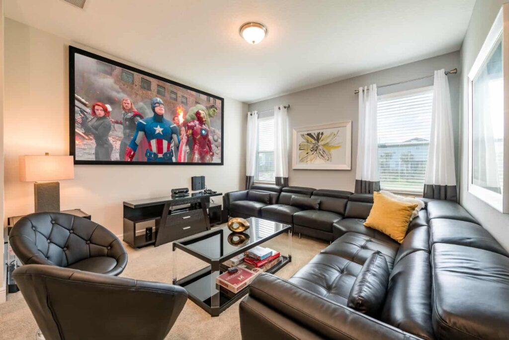 غرفة معيشة مع أريكة مقطعية وطاولة قهوة وتلفزيون مثبت على الحائط في منزل Elite 4 غرف نوم