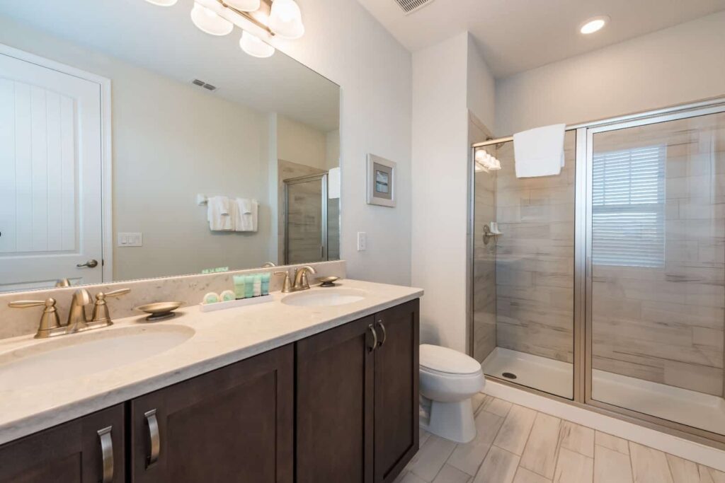 Badezimmer mit Doppelwaschbecken und ebenerdiger Dusche in einem Elite-Haus mit 8 Schlafzimmern