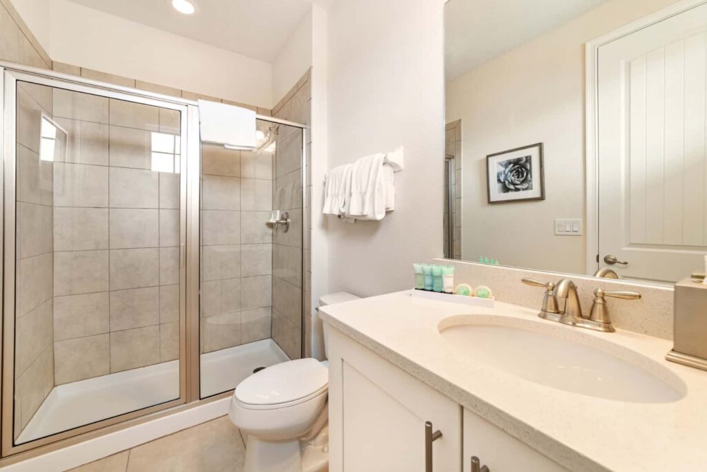 Badezimmer mit ebenerdiger Dusche, Waschbecken und Toilette in einem Elite-Haus mit 8 Schlafzimmern