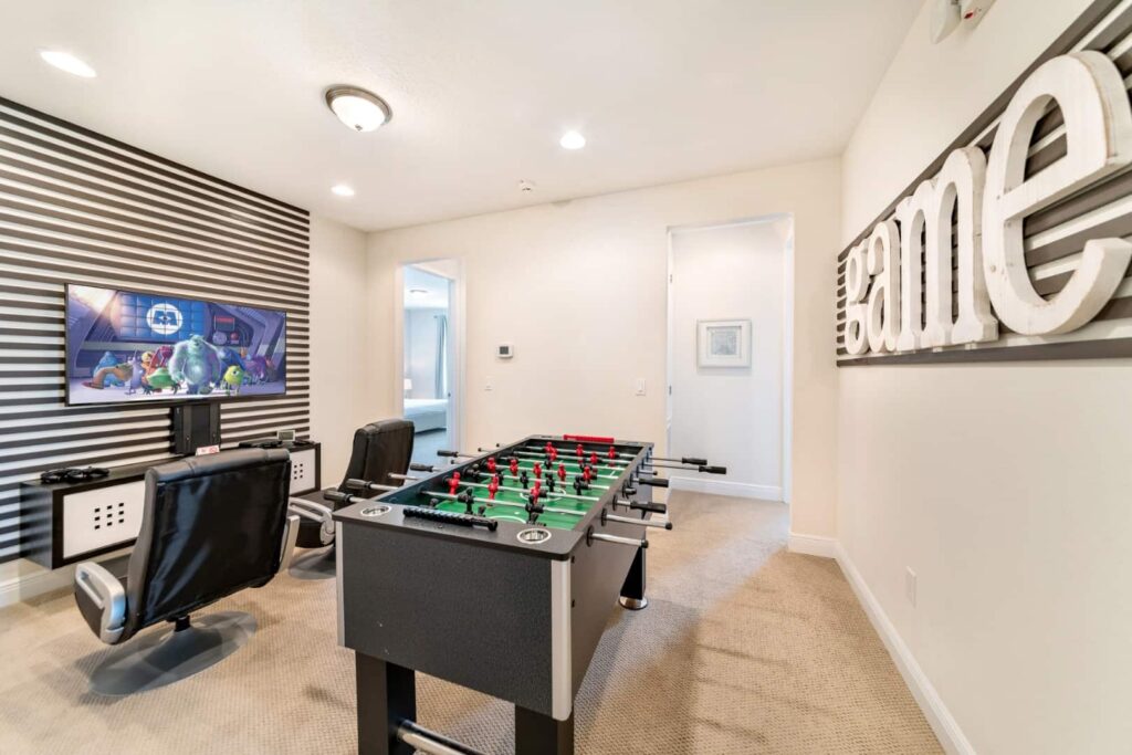 غرفة ألعاب مع وحدة ألعاب وحدة التحكم وطاولة كرة القدم في منزل Elite 8 غرف نوم