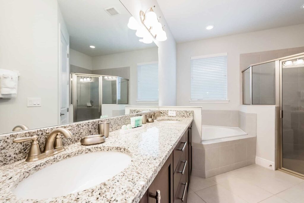 Bathroom 1 with double sinks, walk-in shower, and separate bathtub