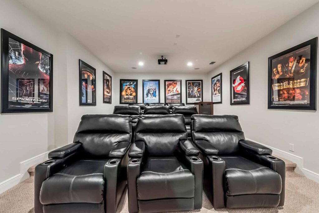 Home theater room with multi-level rows of leather recliners and framed movie posters