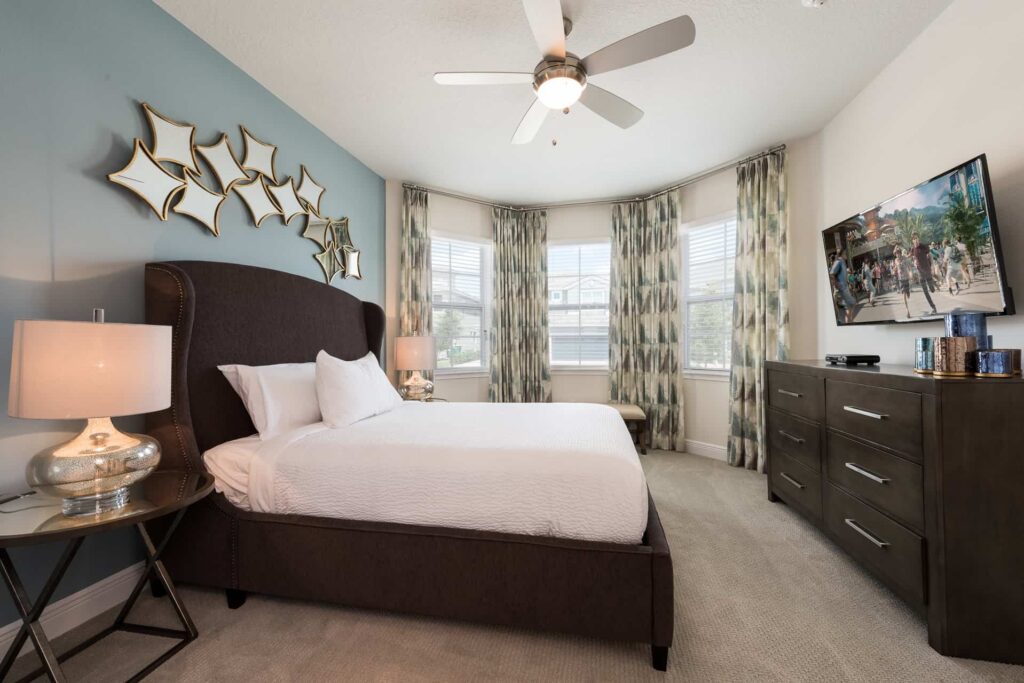Bedroom 4 with queen bed, twin nightstands, dresser, and wall-mounted TV