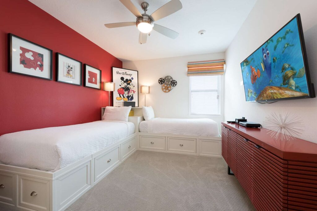 Bedroom 9 with twin single beds, shared corner nightstand, dresser, and wall-mounted TV