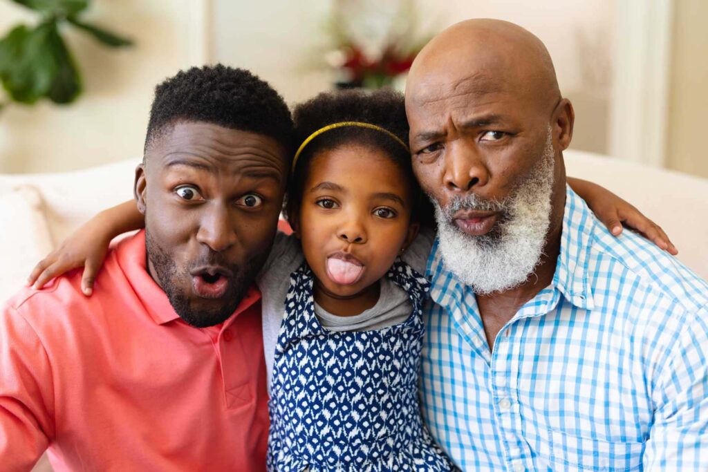 Dad, daughter, and grandpa making silly faces for the camera