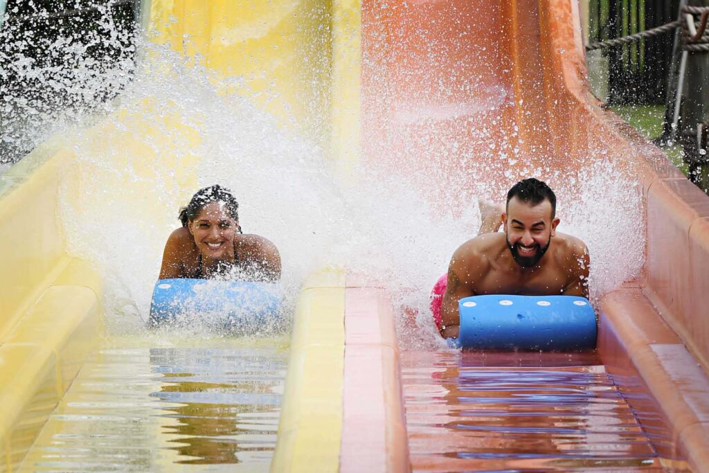 Paar geht die Wasserrutsche hinunter Encore Resort-Wasserpark