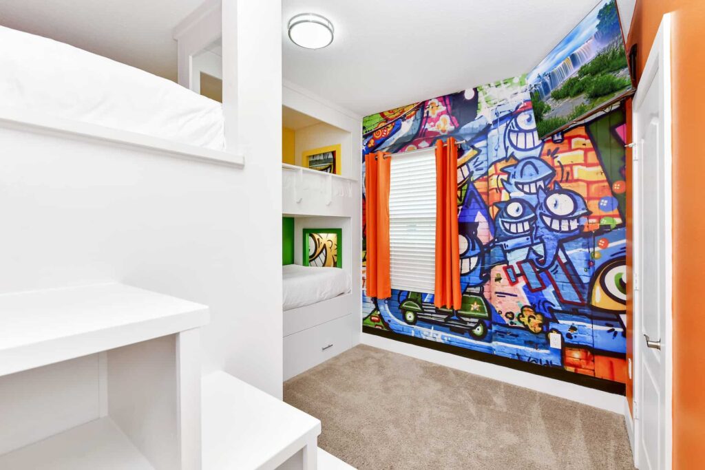 Schlafzimmer 4 im Reunion Village 4-Zimmer-Haus mit farbenfroher Wandmalerei, 4 eingebauten Etagenbetten und an der Wand montiertem Fernseher