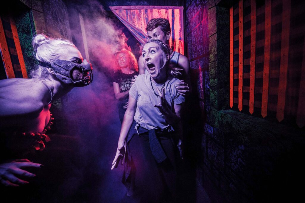 Frau schreit ein Monster bei den Halloween Horror Nights von Universal an