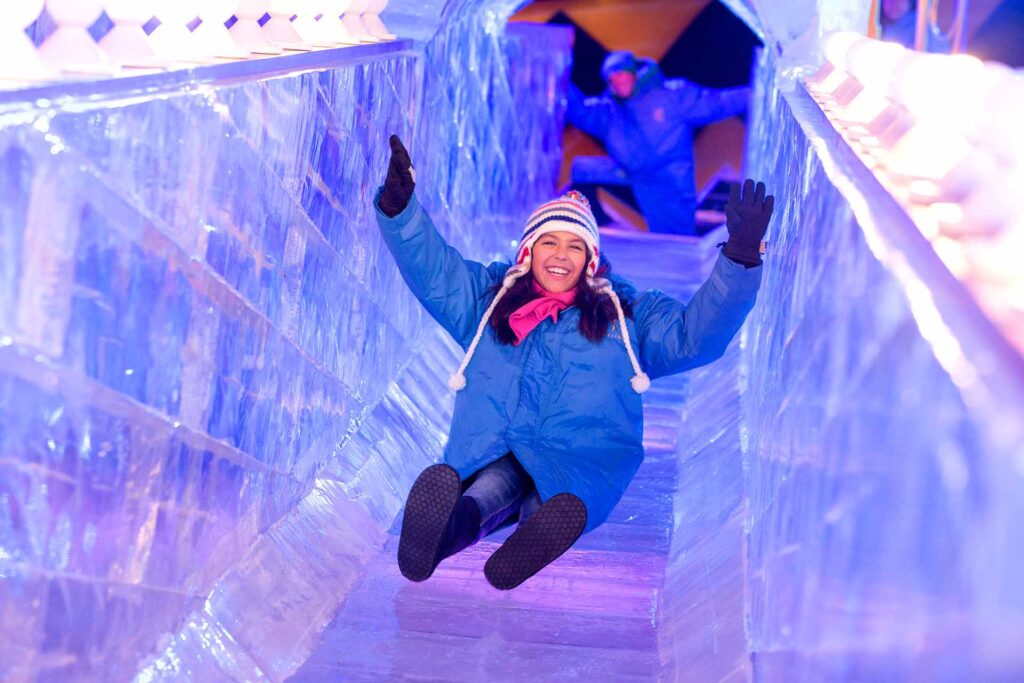 Garota descendo o escorregador de gelo no evento de Natal do Gaylord Palms