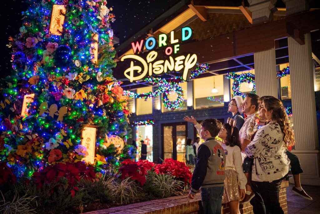 Family admiring the Christmas tree outside of the World of Disney store in Disney Springs