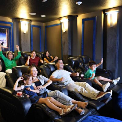 A large family watching something exciting in their Encore Resort home movie theater room.