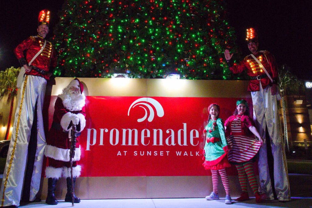 Papai Noel, seus duendes e soldadinhos de brinquedo em frente à árvore de Natal Promenade at Sunset Walk