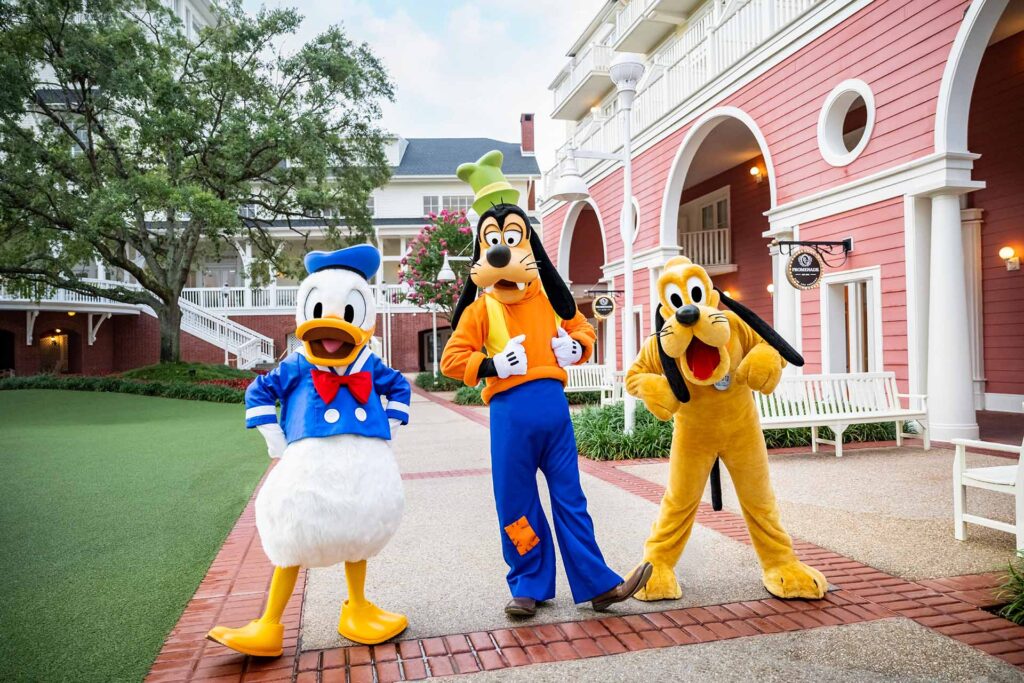 Donald Duck, Goofy, and Pluto walking around the Boardwalk Resort at Walt Disney World