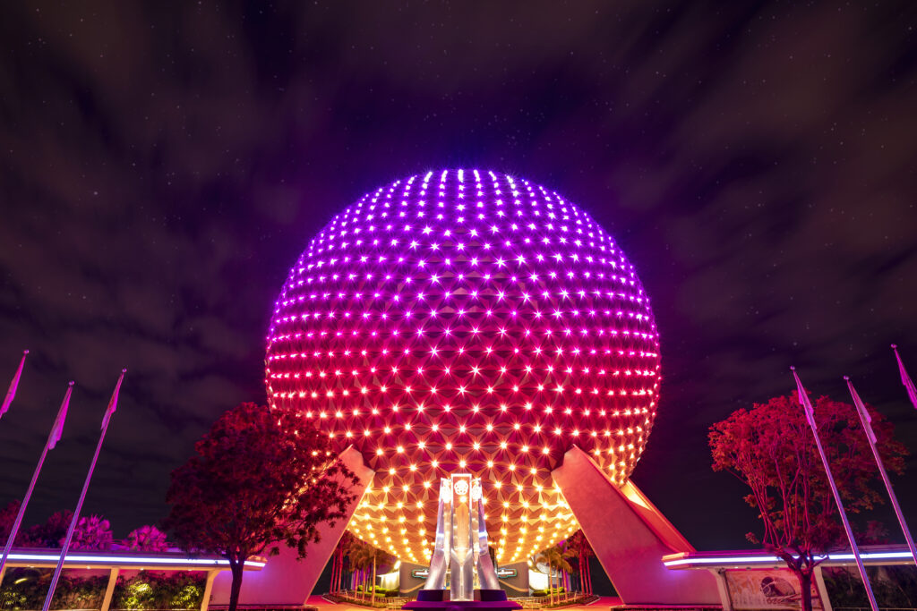 Spaceship Earth exterior lit up with multicolor lights at night
