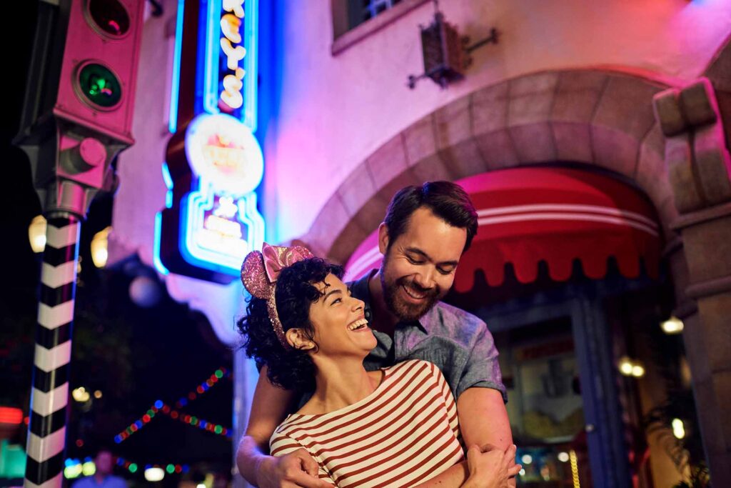 Casal feliz na Sunset Boulevard à noite no Disney's Hollywood Studios