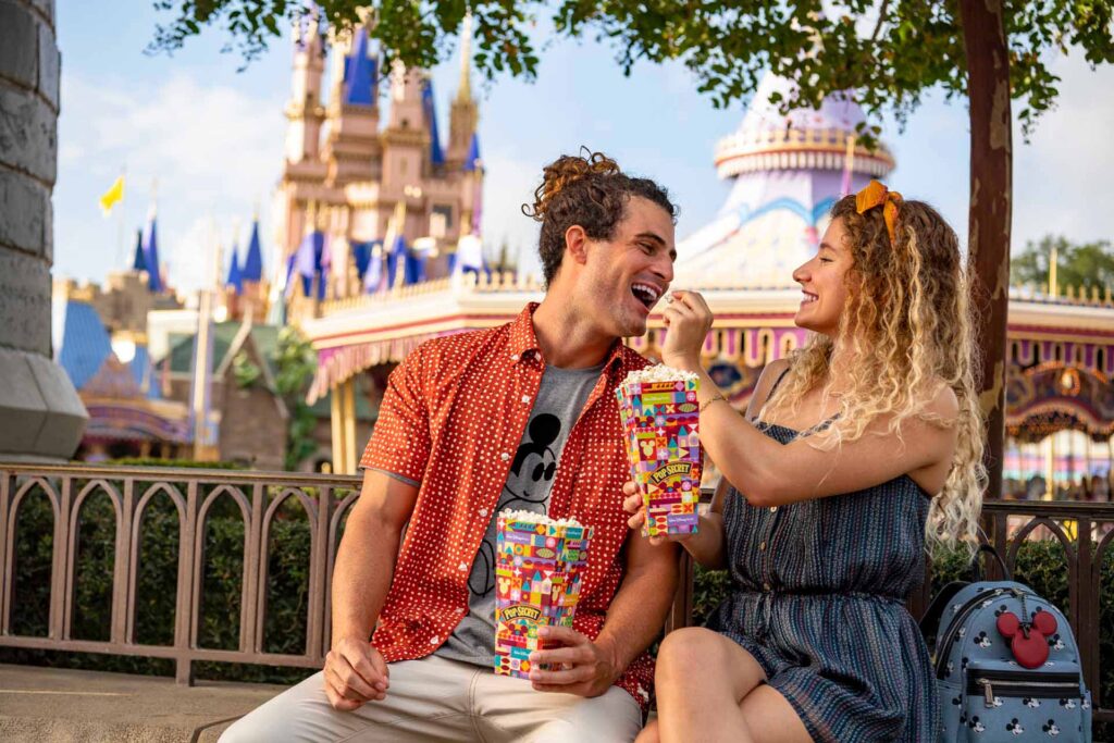 Happy couple feeding each other popcorn at the Magic Kingdom
