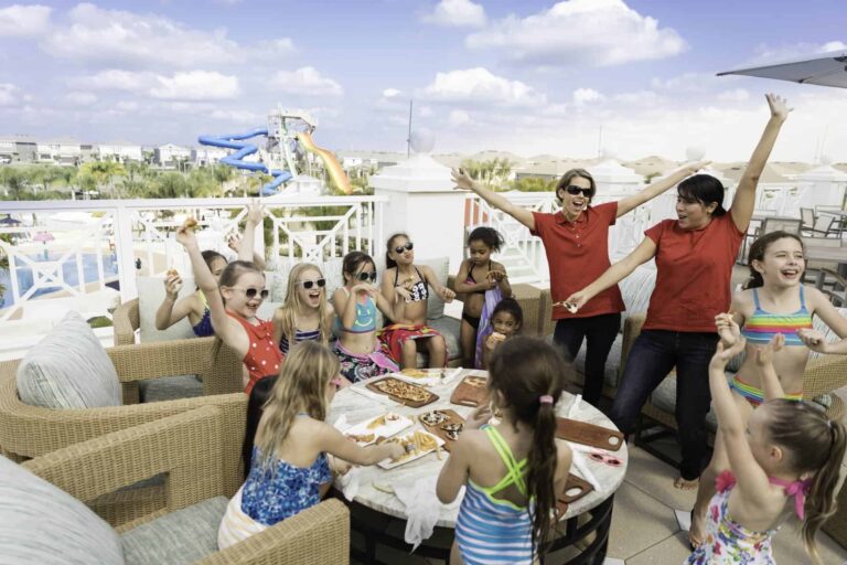 Grupo de niños almorzando durante una Encore Fiesta organizada por el resort en la terraza al aire libre de la casa club