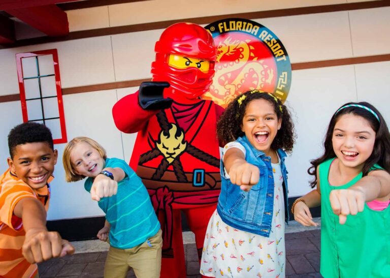 Kids posing for a photo with a LEGO Ninja character