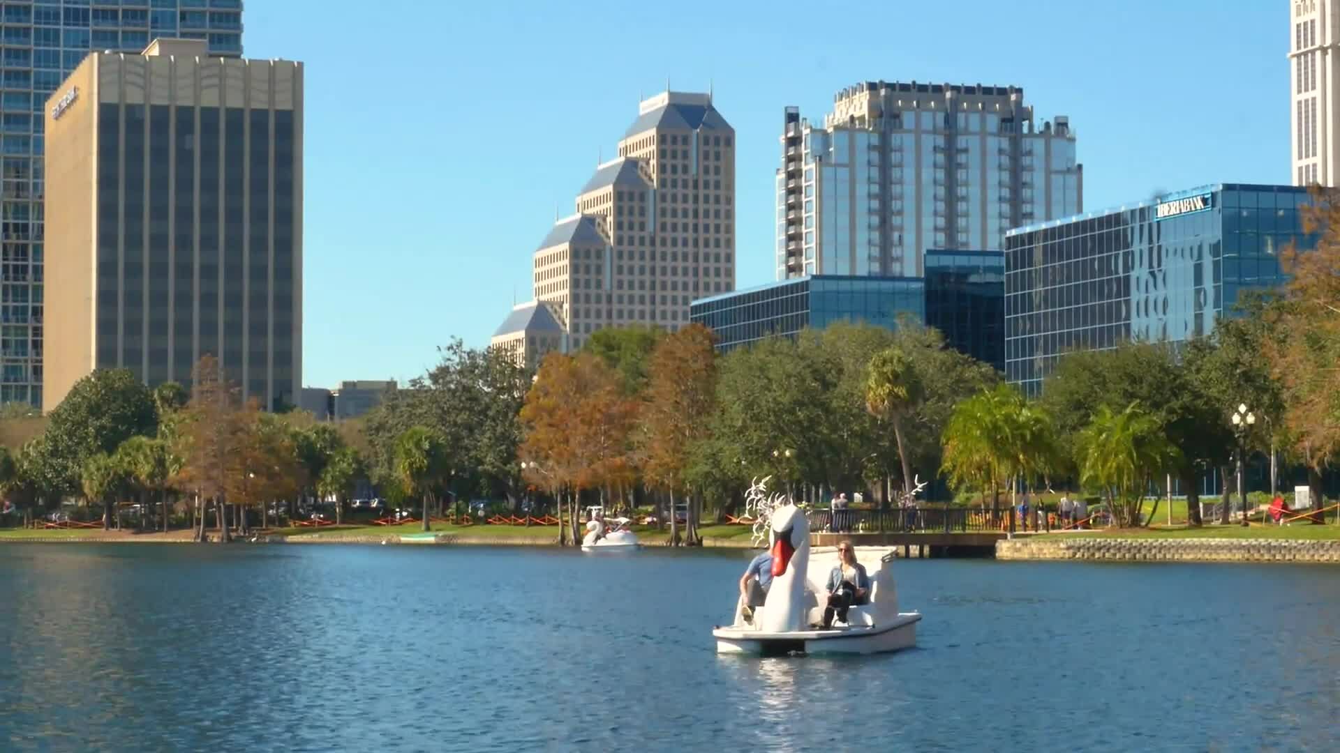 People riding on swan boats at Lake Eola Park in downtown Orlando