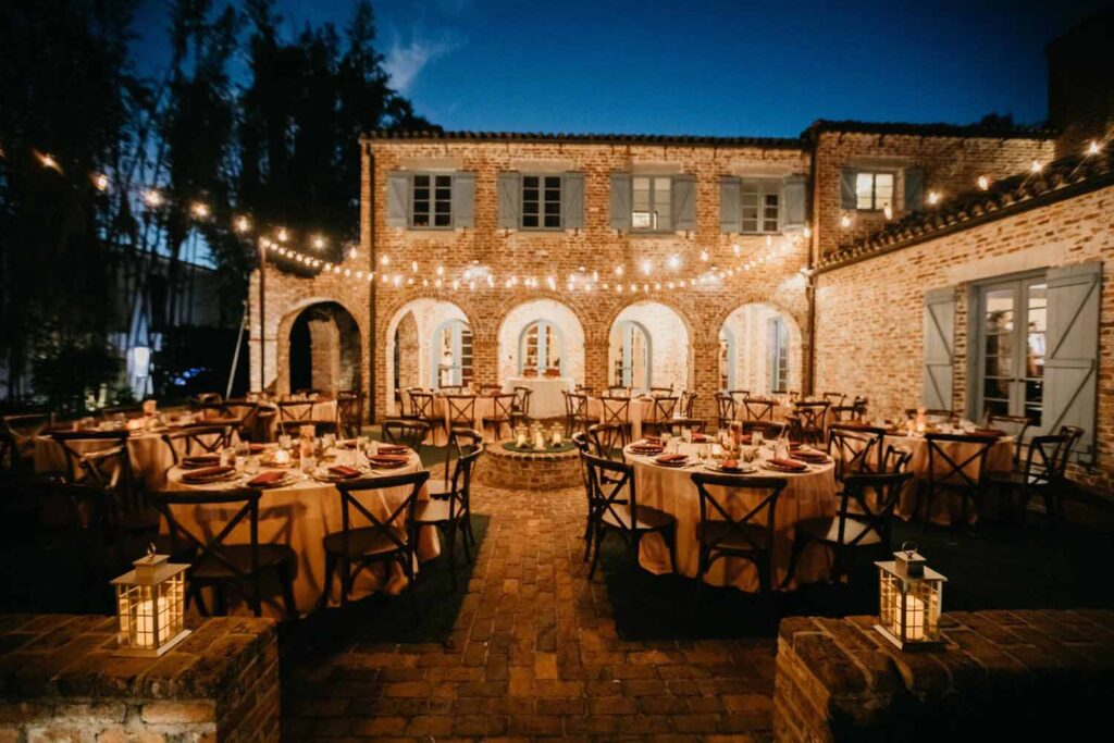Outdoor, nighttime wedding reception at a historic brick mansion